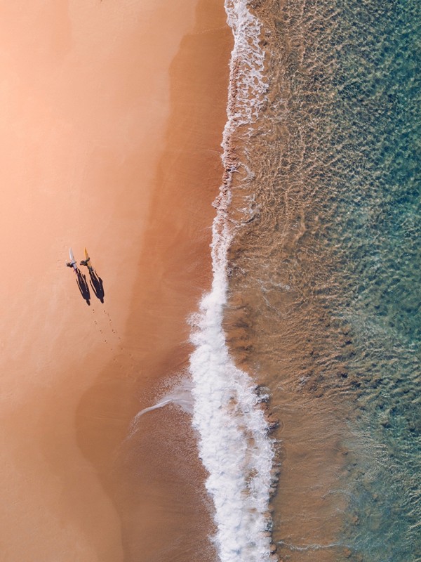 Two surfers walking on the beach